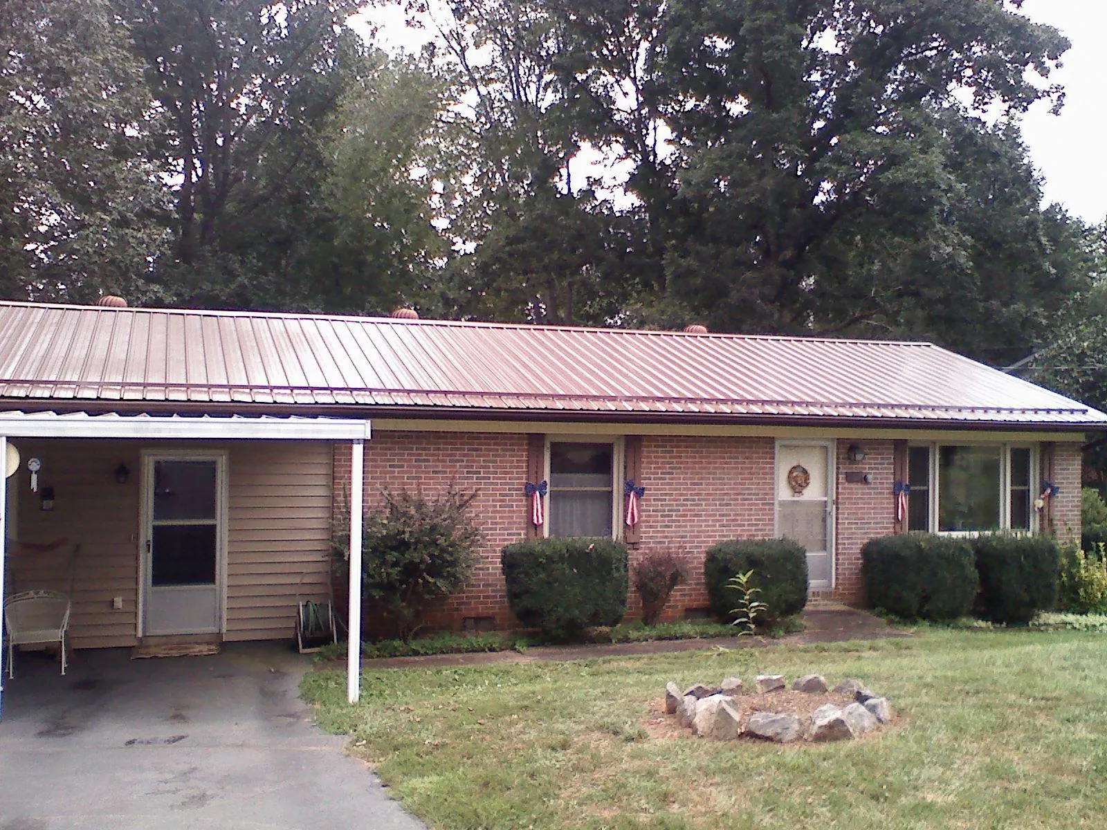 Bronze metal roof and carport on a brick ranch home — Roof Repair work by our crew in Waitsburg